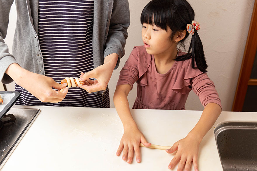 パン生地を手で伸ばします。